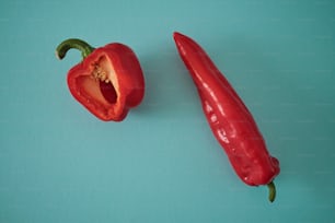 eine rote Paprika und eine rote Paprika auf blauem Hintergrund