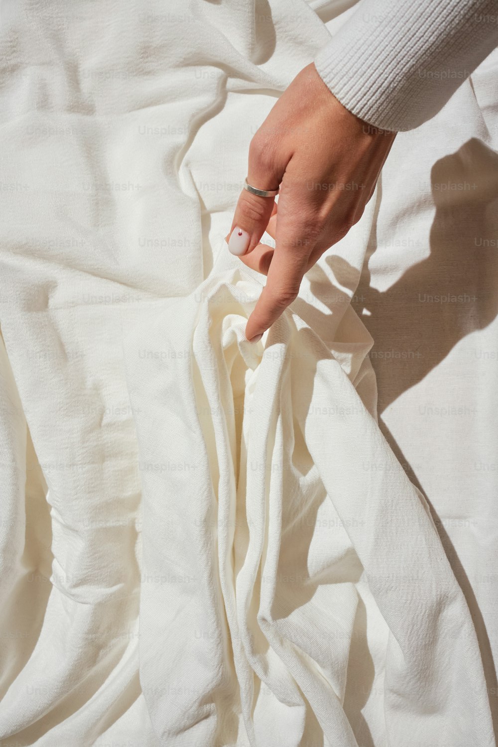 a mão de uma pessoa em cima de um lençol branco