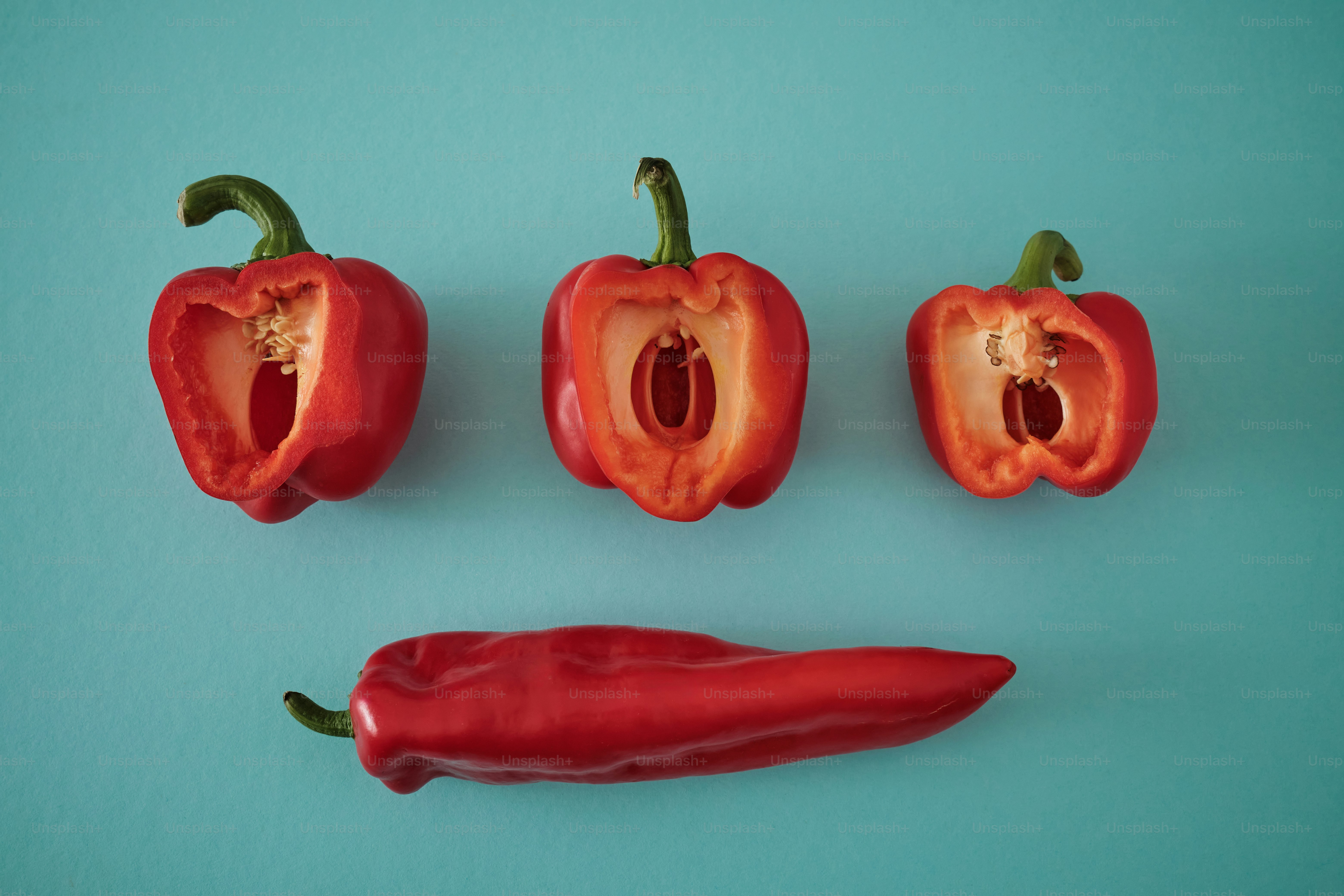 a group of red peppers sitting on top of a blue surface