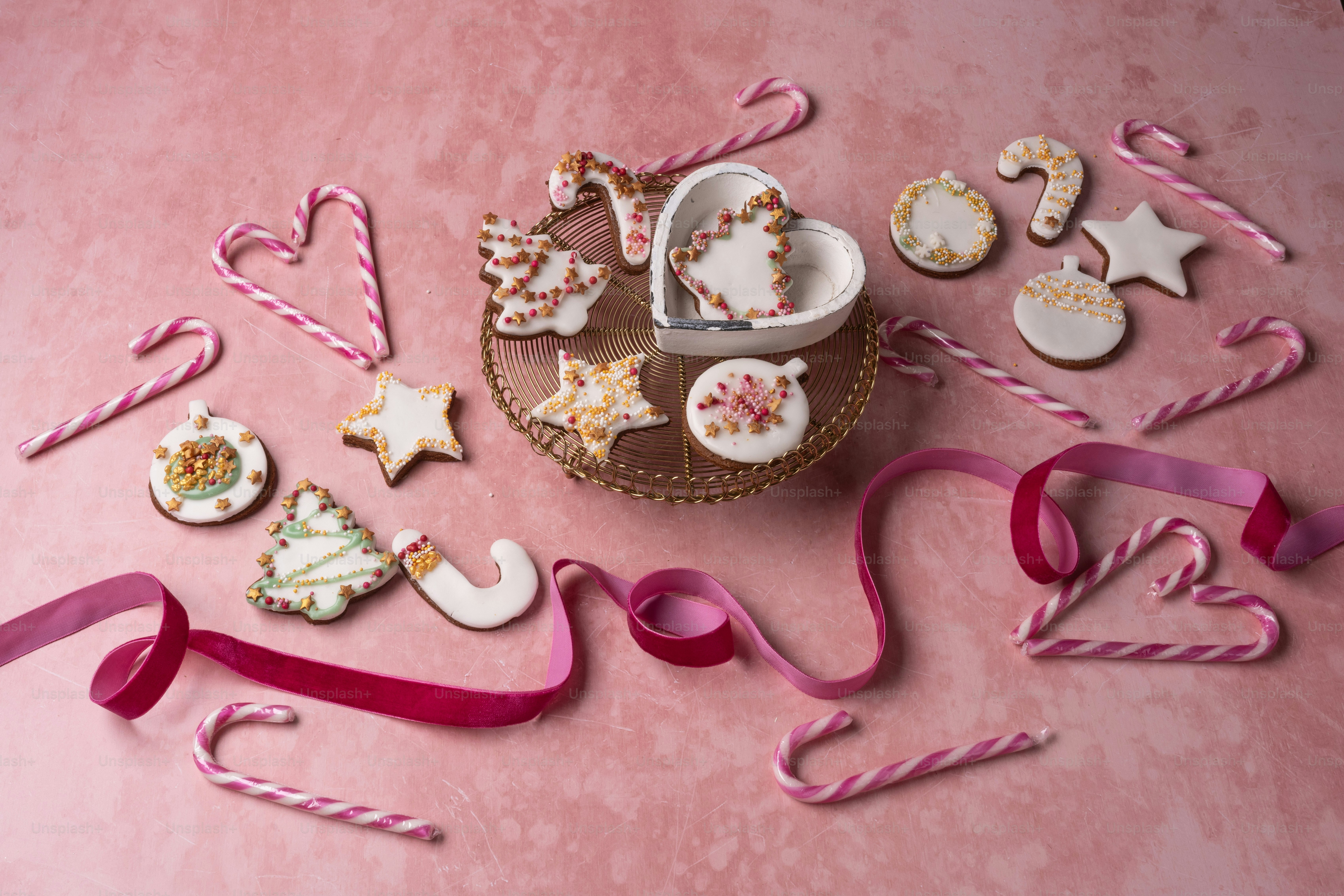 a pink table topped with lots of cookies and candy