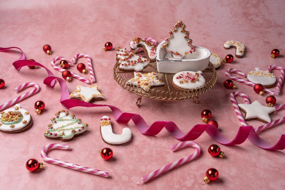 una mesa rosa cubierta con muchas galletas decoradas