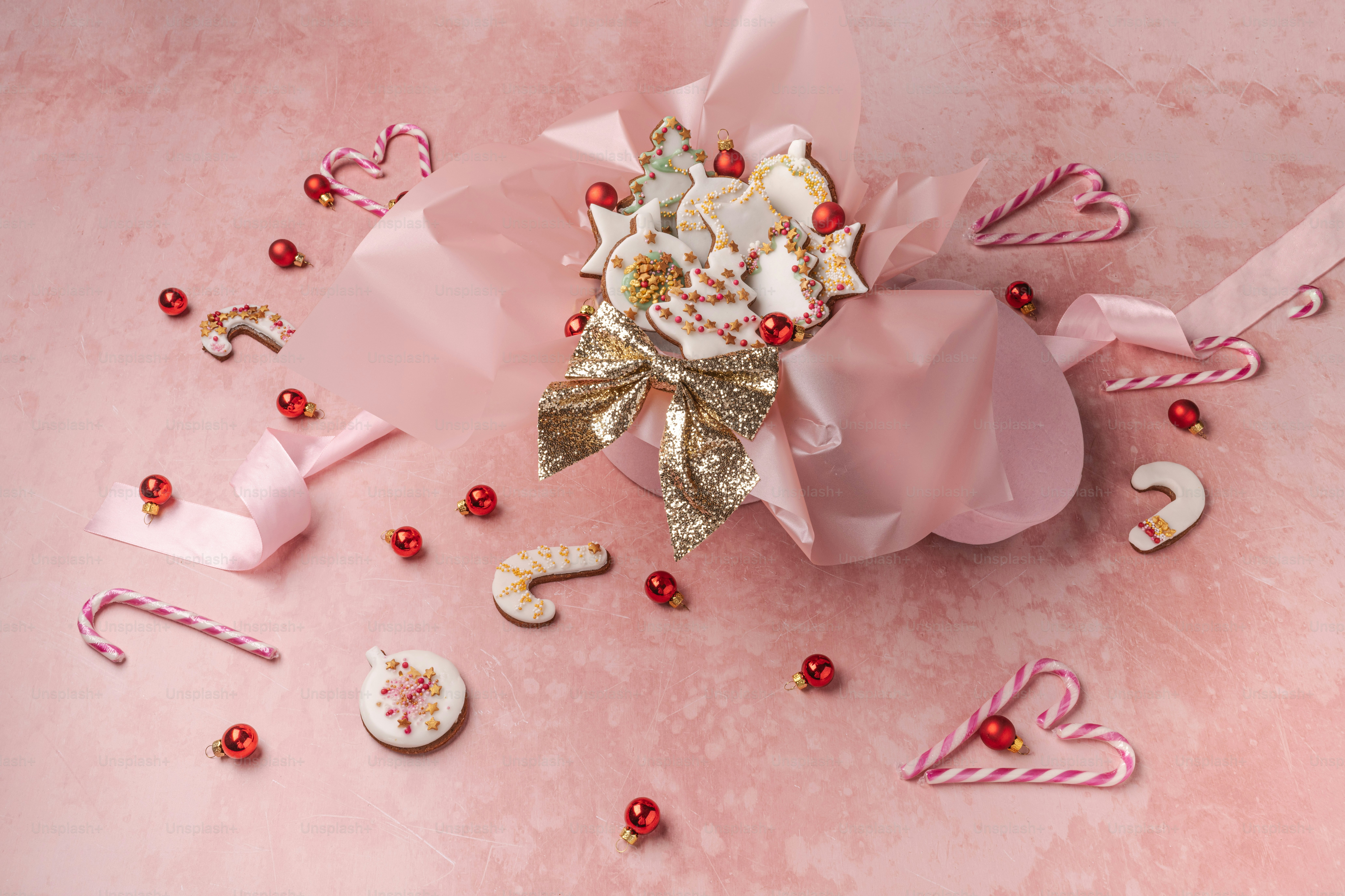 a bouquet of flowers and candy canes on a pink background
