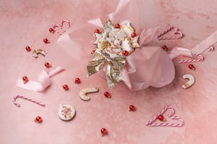 un ramo de flores y bastones de caramelo sobre un fondo rosa