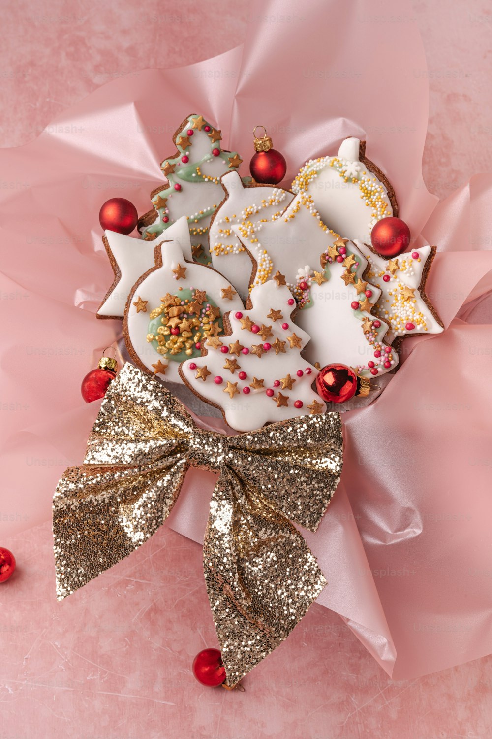 a decorated christmas cookie on a pink background