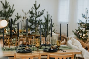 a wooden table topped with black plates covered in candles