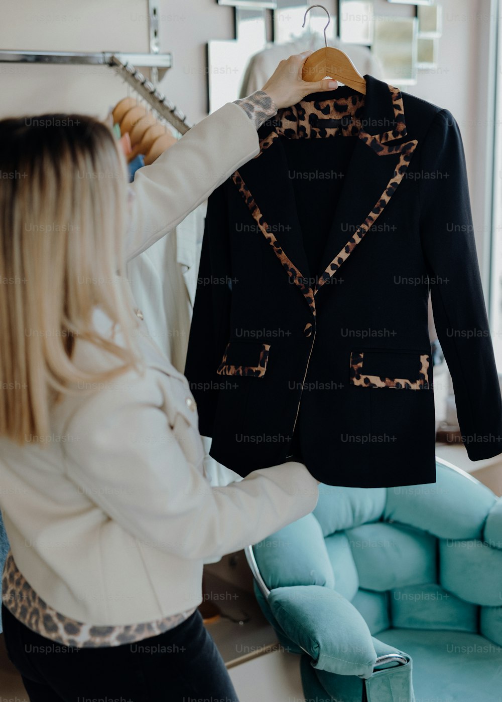 a woman looking at a jacket on a hanger