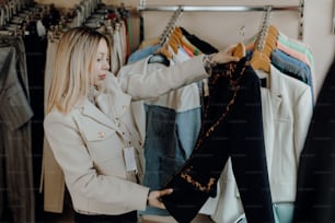 a woman looking at clothes hanging on a rack