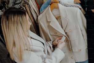 a woman looking at a coat hanging on a rack