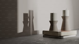 a couple of white candles sitting on top of a book