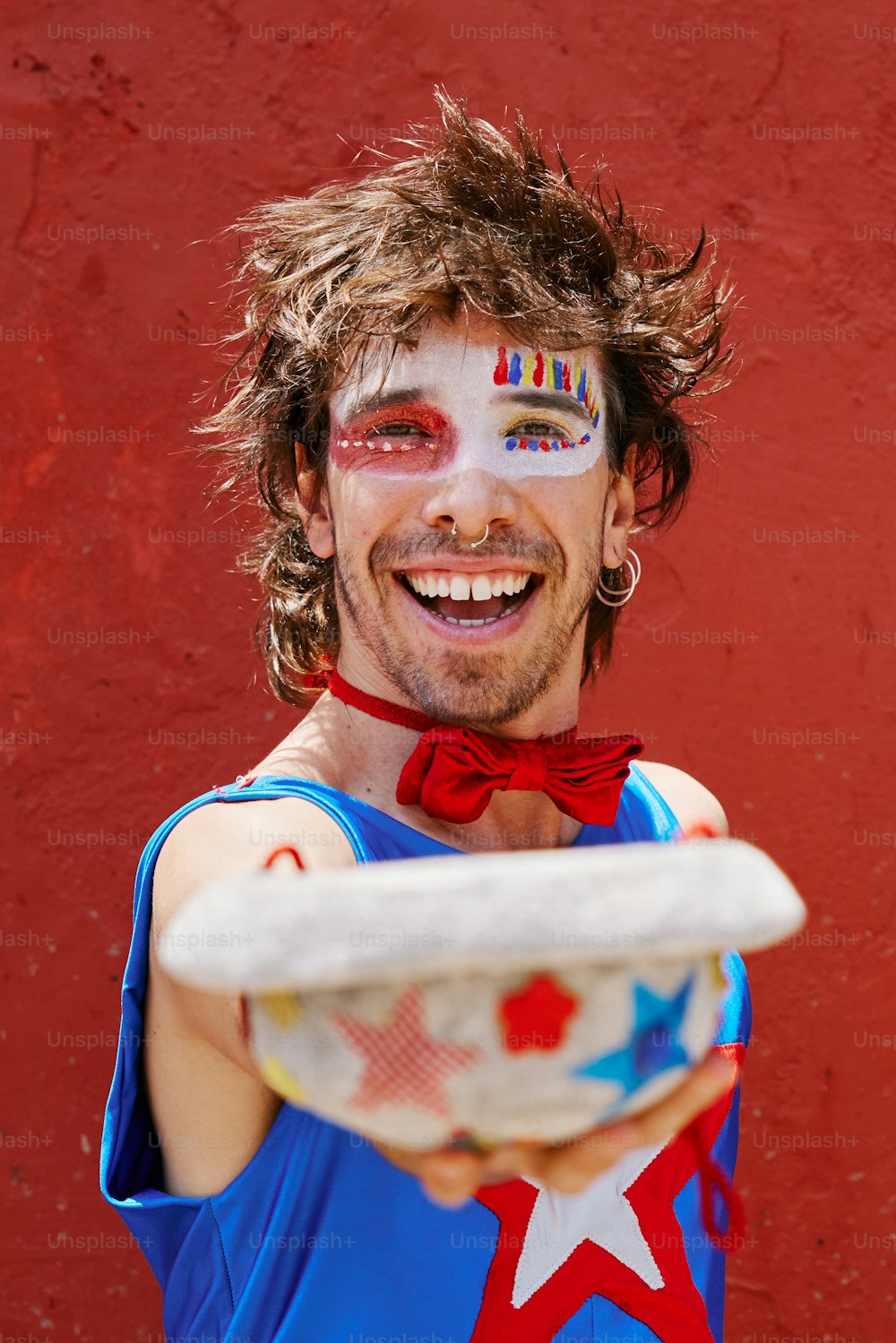 a man with face paint holding a frisbee