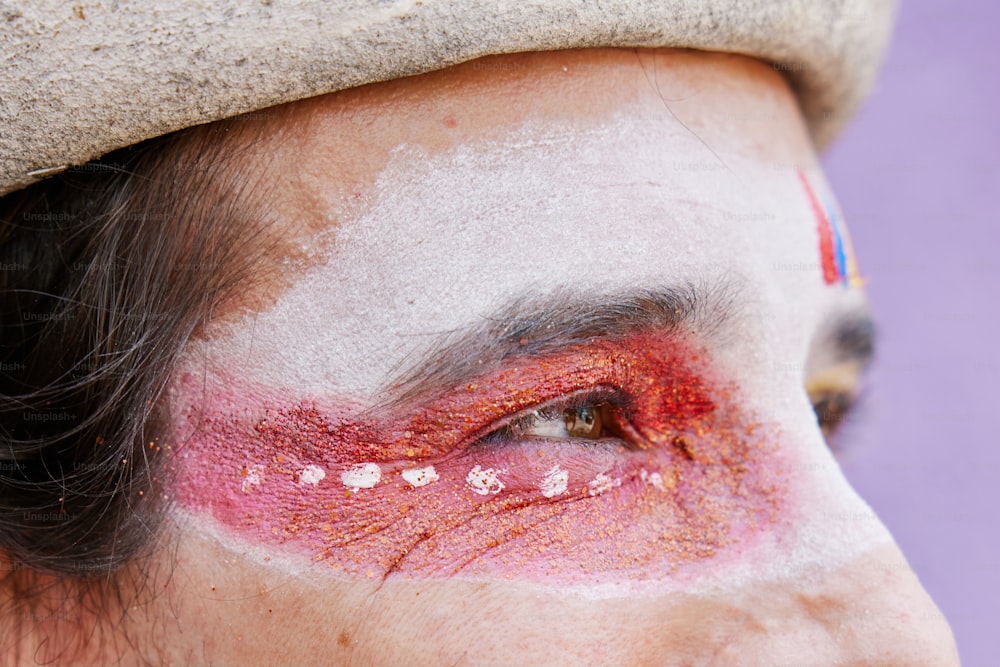 um close up do rosto de uma pessoa com maquiagem vermelha e branca