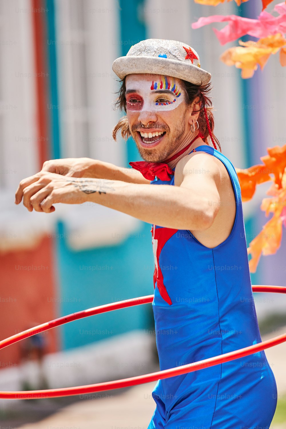 Ein Mann mit Gesichtsbemalung hält einen Hula-Hoop-Reifen in der Hand