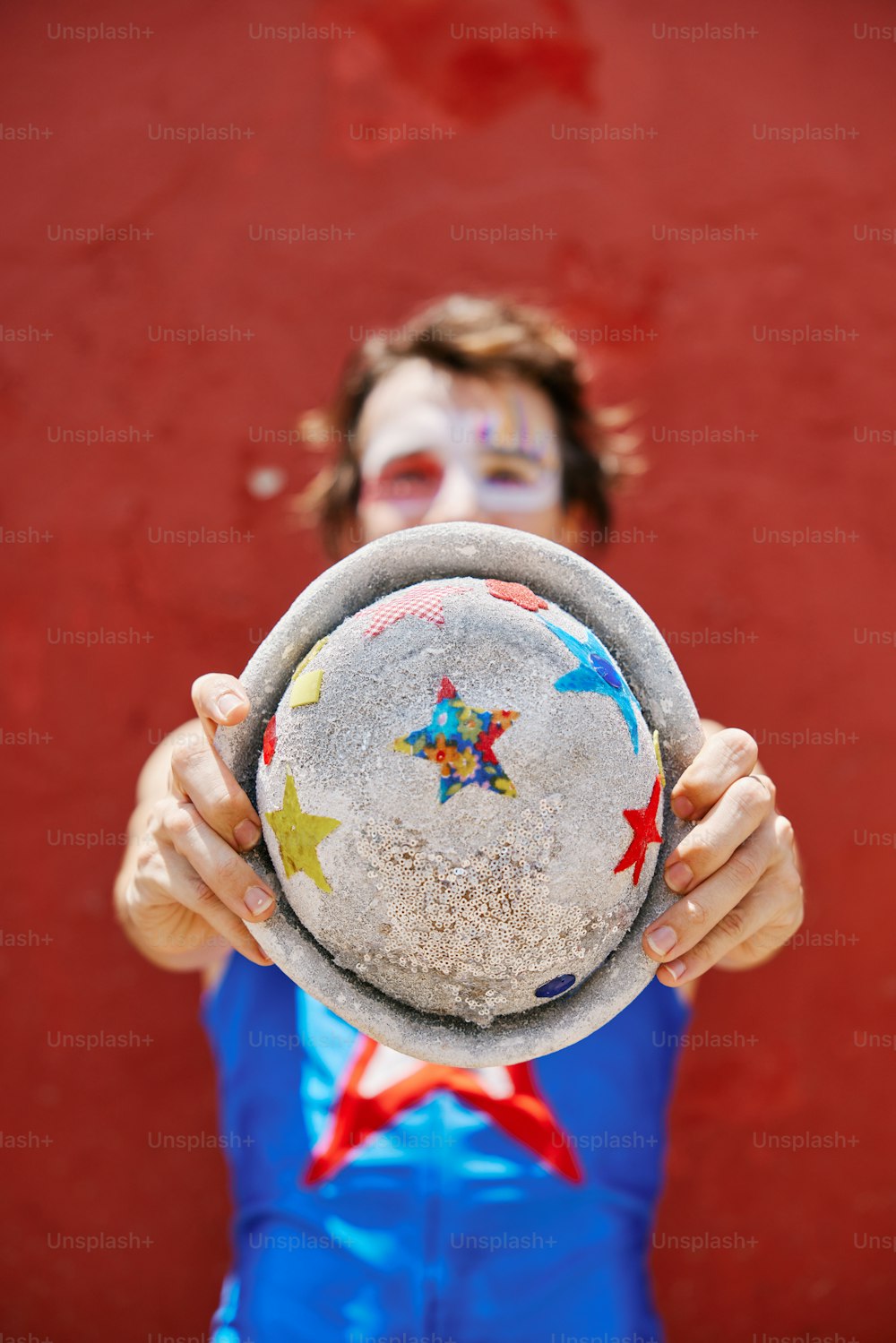 a person wearing a clown makeup holding a plate