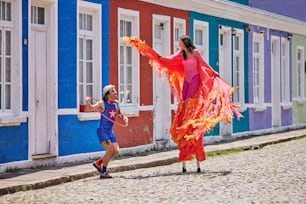 a woman in a red dress is dancing with a girl in a blue dress