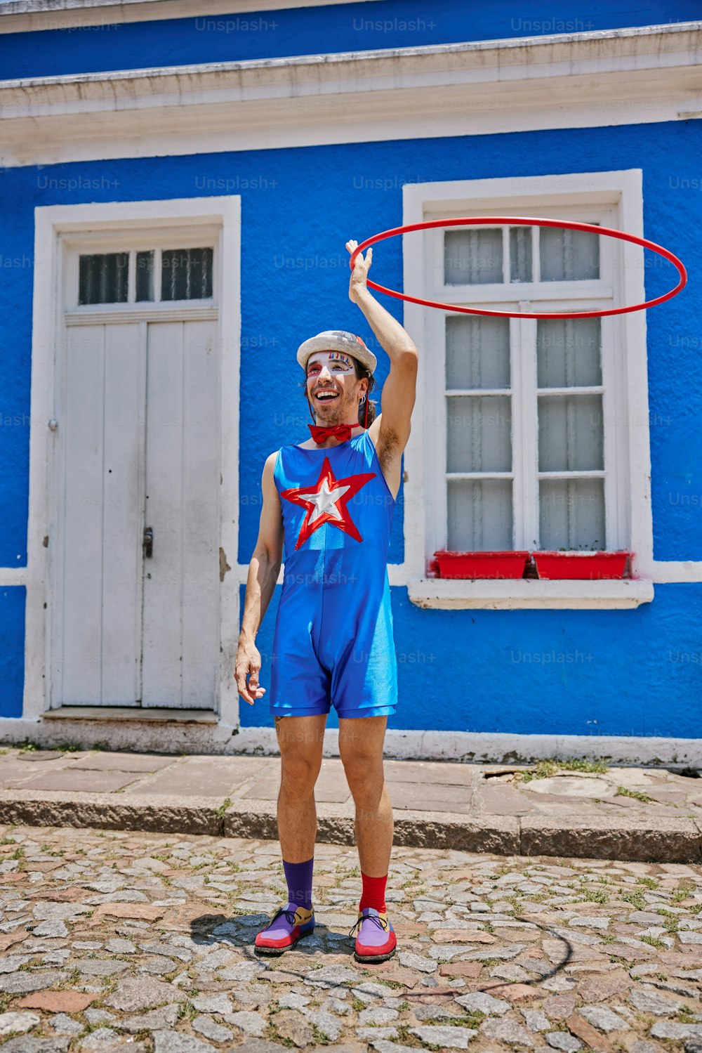 a man in a blue jumpsuit holding a red hoop