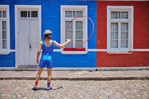 a man holding a hoop in front of a building