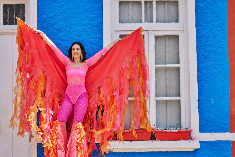 a woman in a pink top and orange wings
