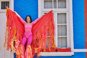 a woman in a pink top and orange wings