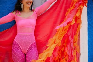 una mujer con un body rosa sosteniendo una bandera roja y naranja