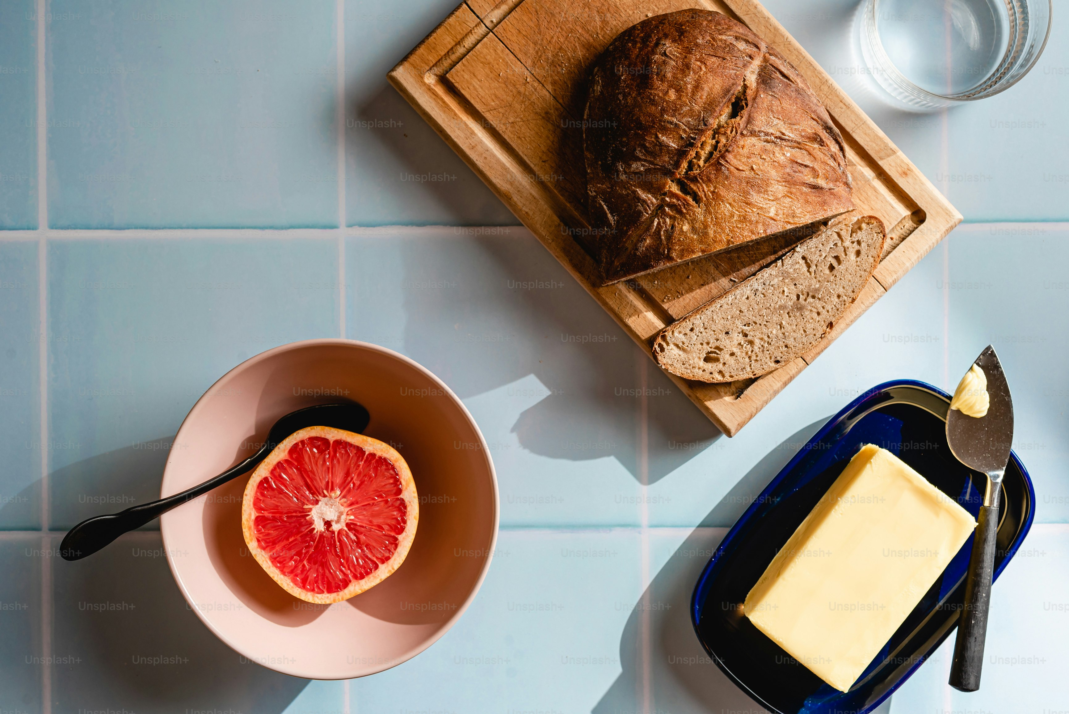 a table topped with a bowl of fruit and a loaf of bread