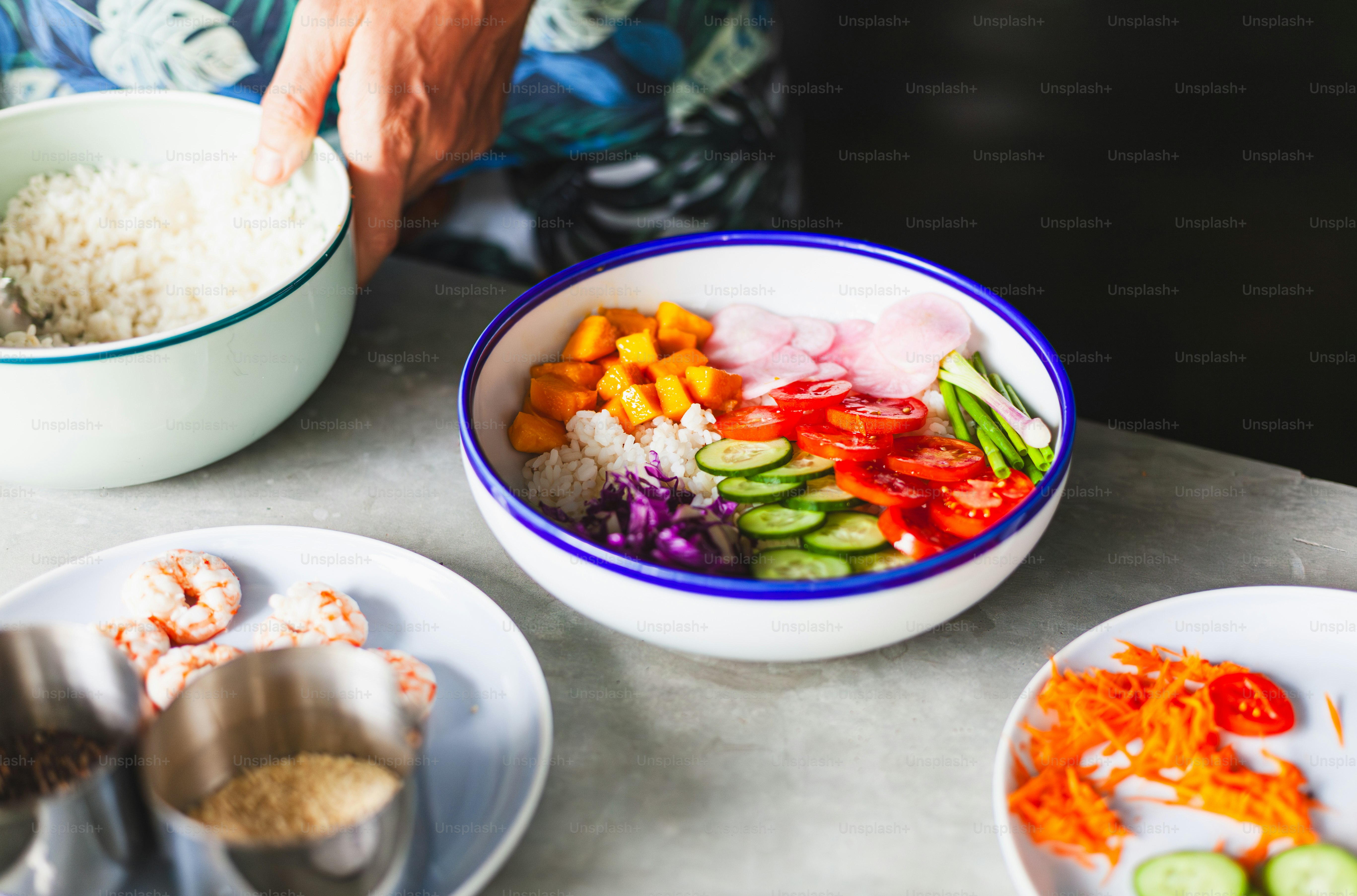 a bowl of rice, carrots, cucumbers, and other vegetables