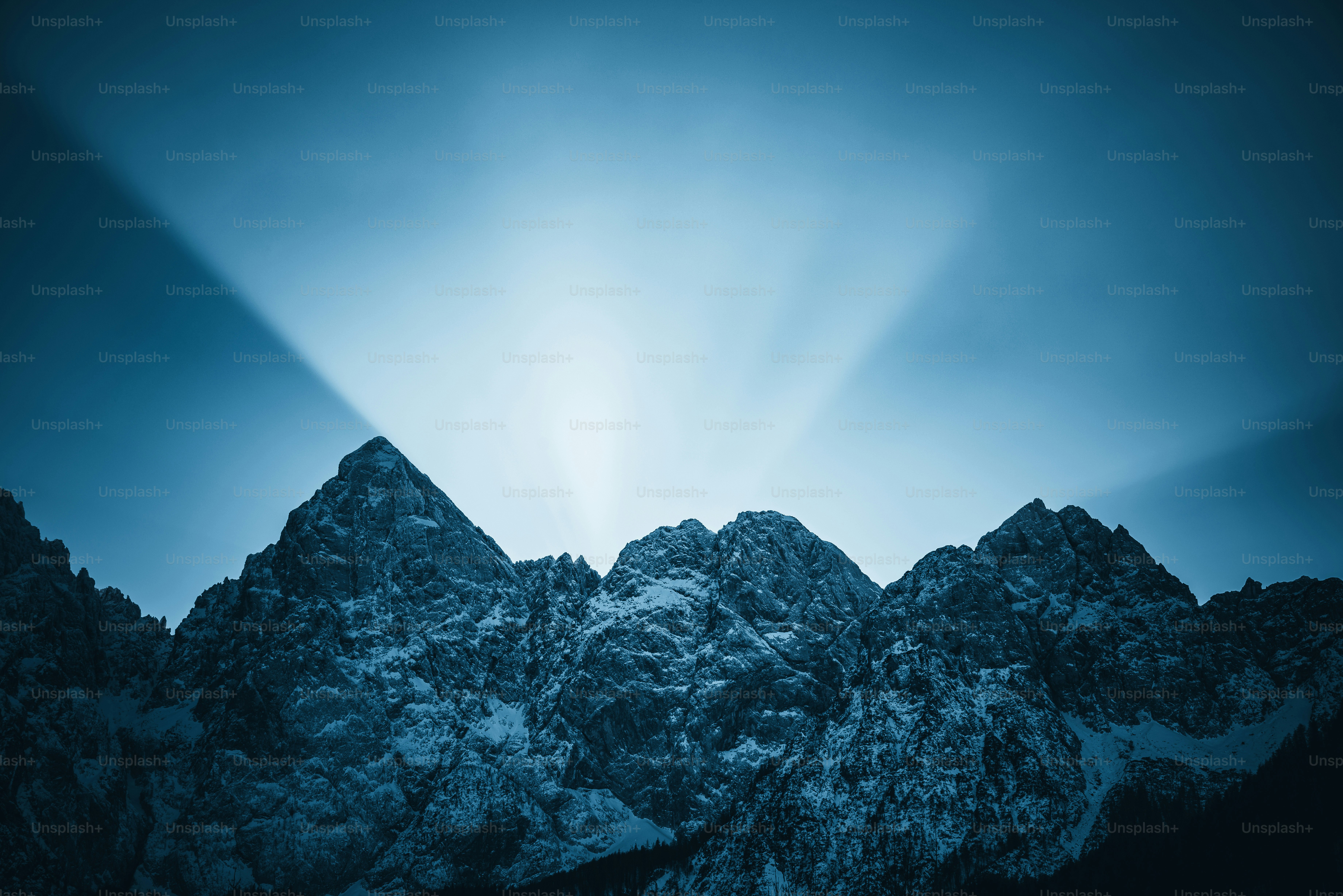 el sol brilla a través de las nubes sobre las montañas