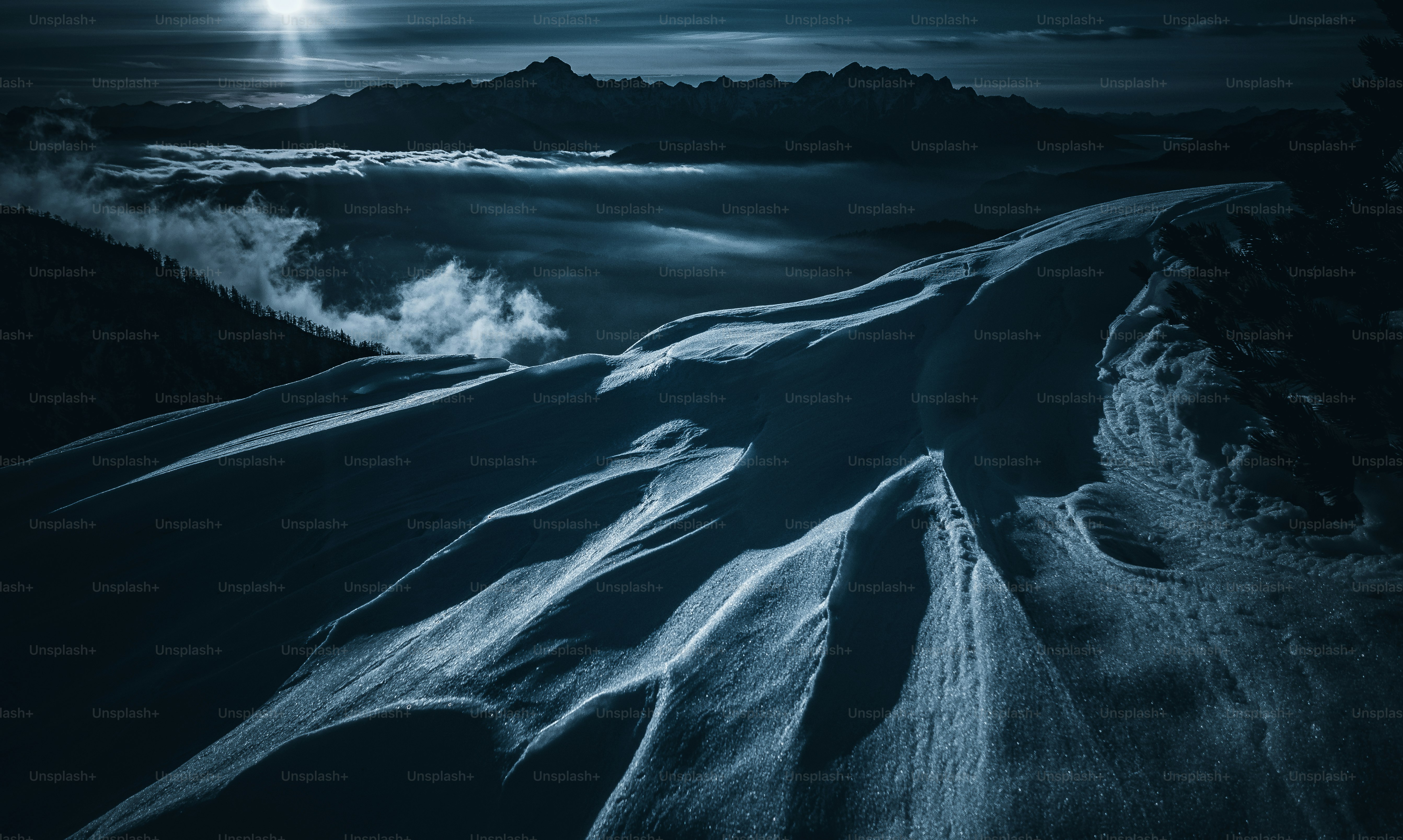 una luna llena brilla sobre una montaña nevada