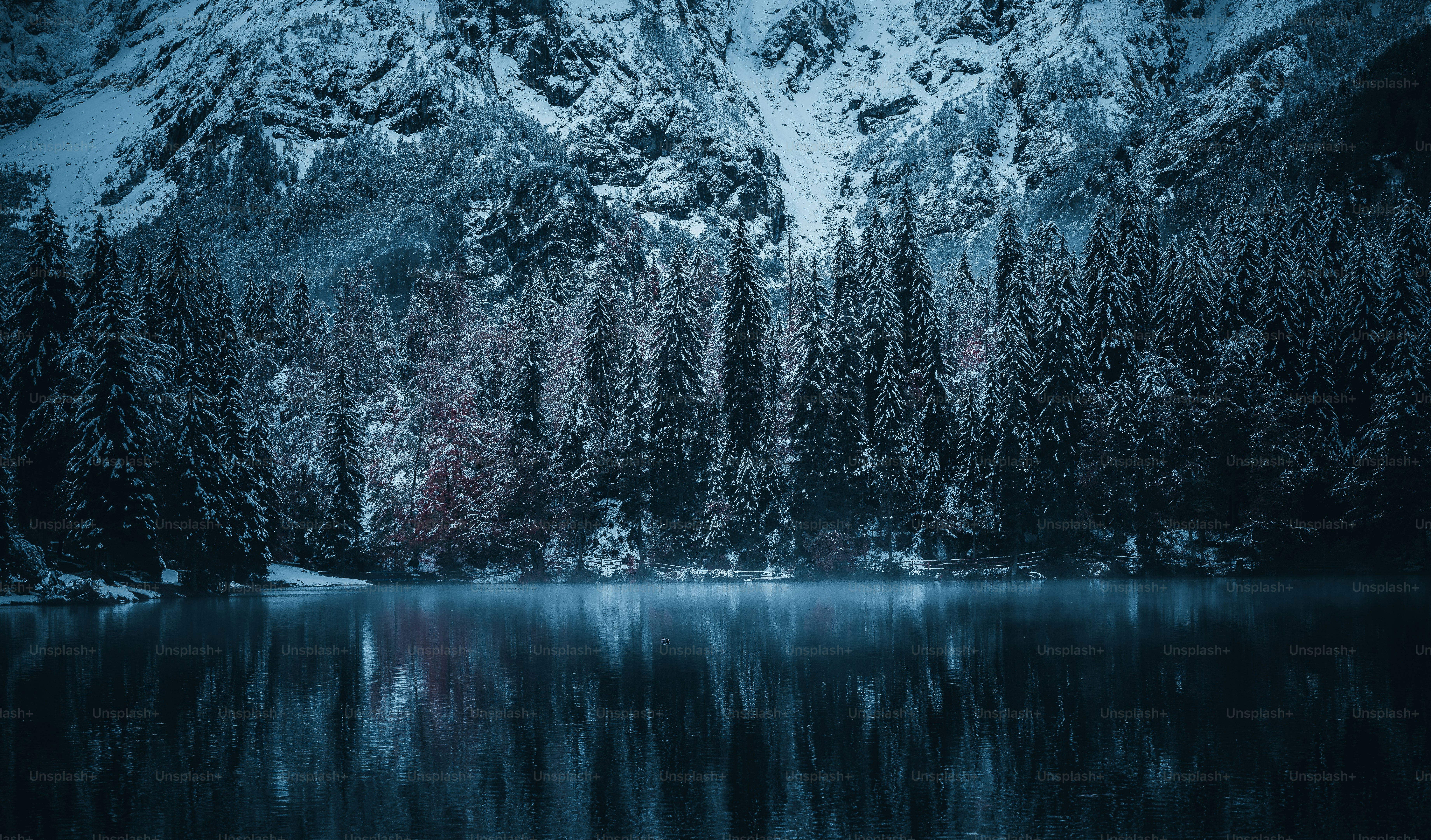 ein schneebedeckter Berg neben einem See