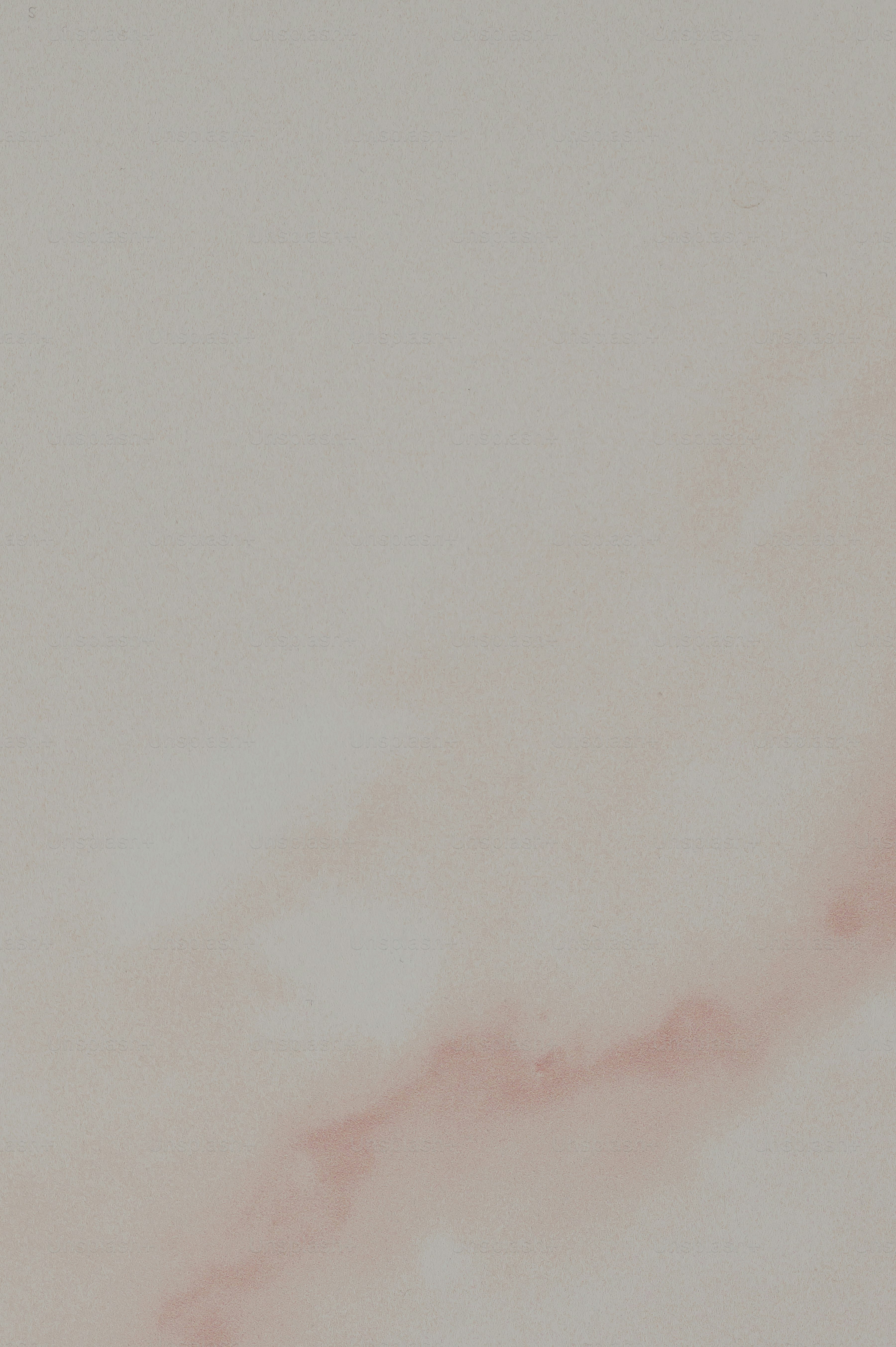 an airplane flying in the sky with a pink cloud