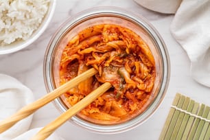 a bowl of noodles and chopsticks on a table