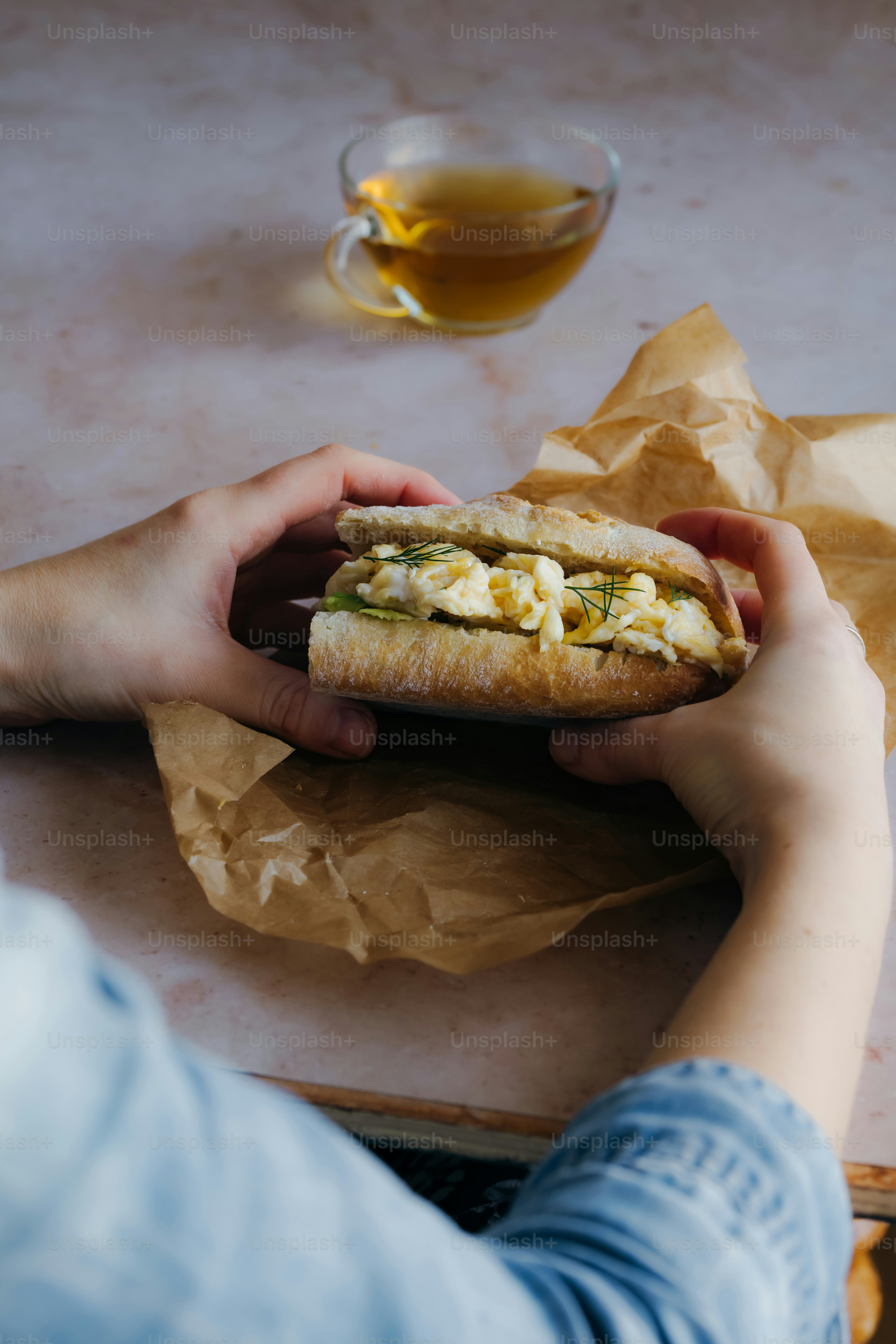 a person holding a sandwich in their hand