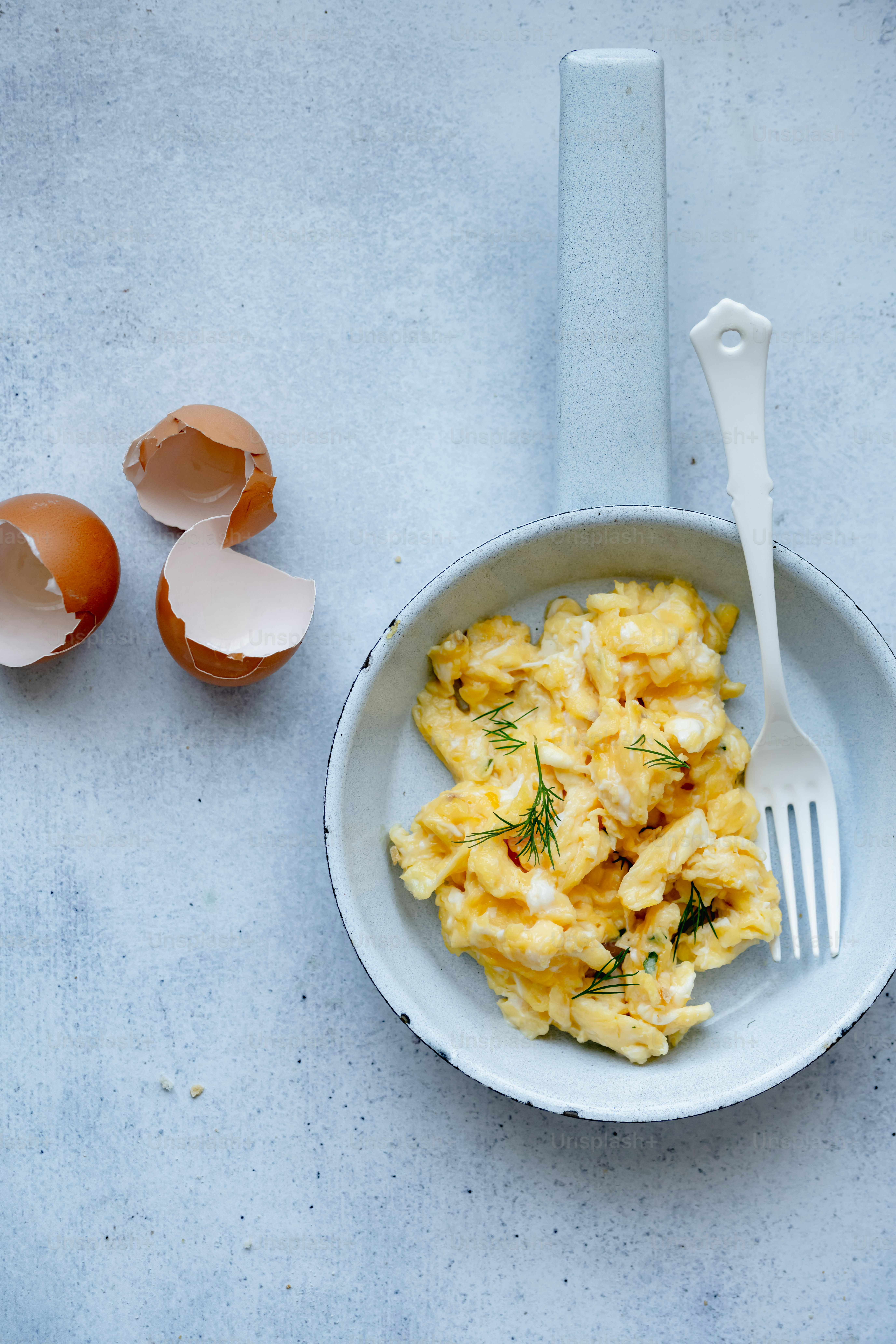 a bowl of eggs and a fork on a table