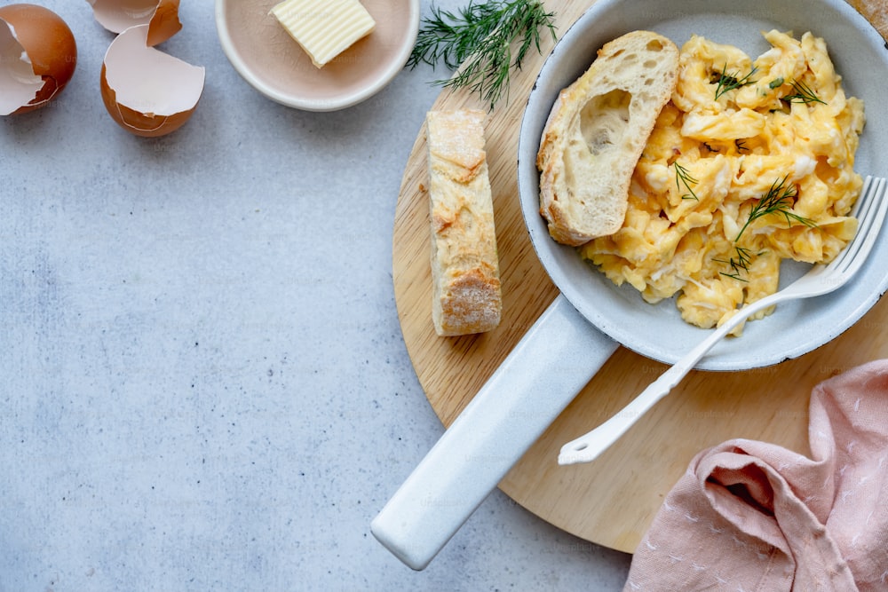 a bowl of scrambled eggs on a cutting board