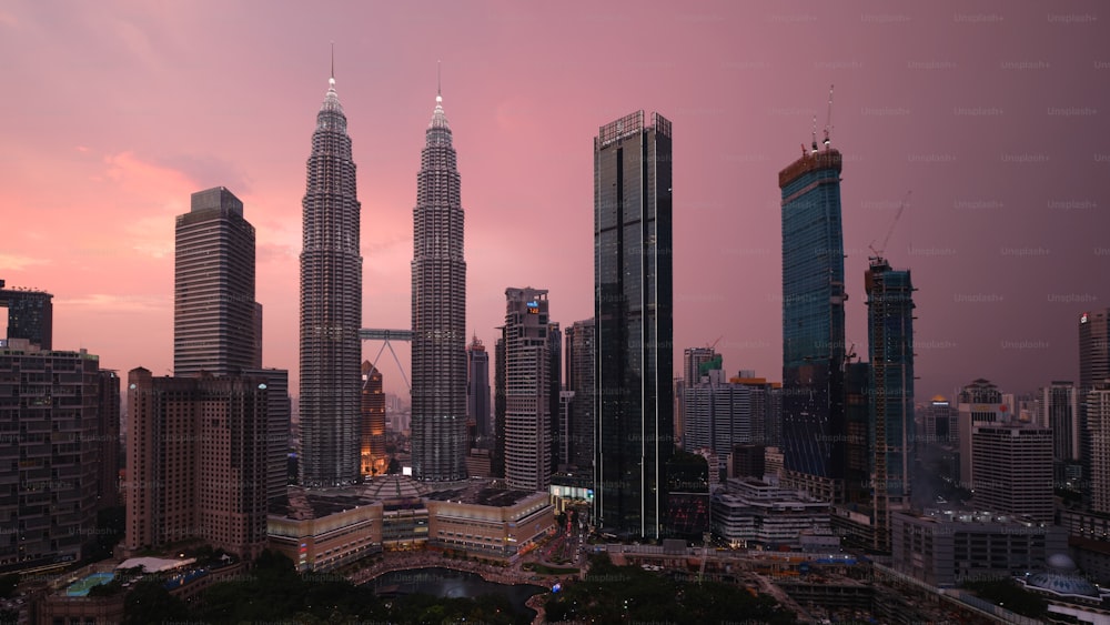 a view of a city at sunset with tall buildings