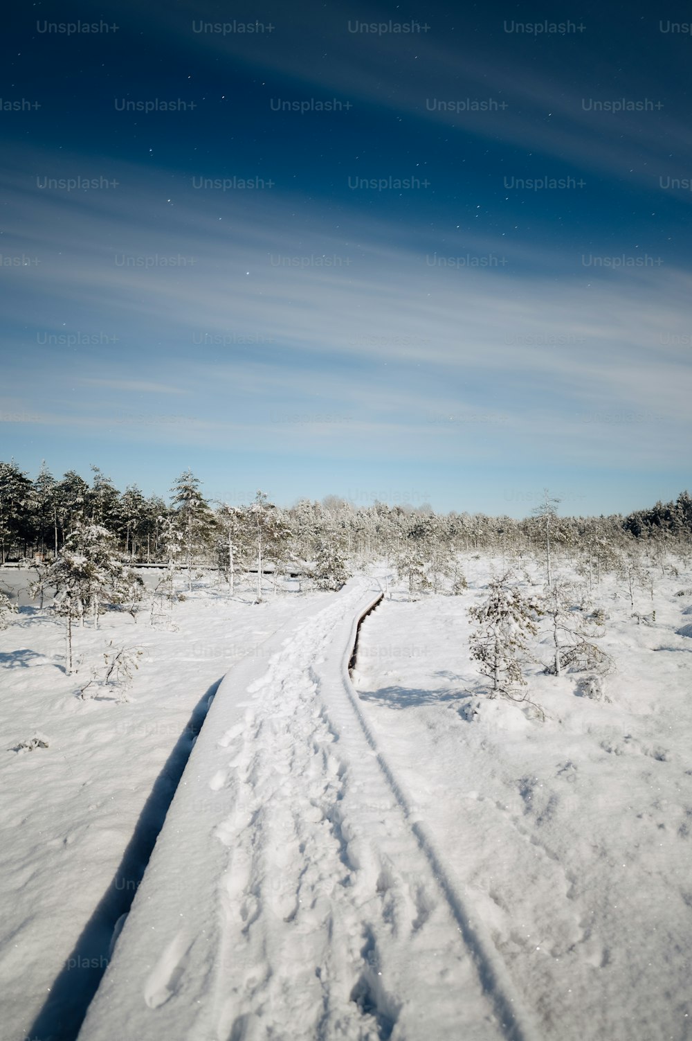 a path in the snow with a sky background