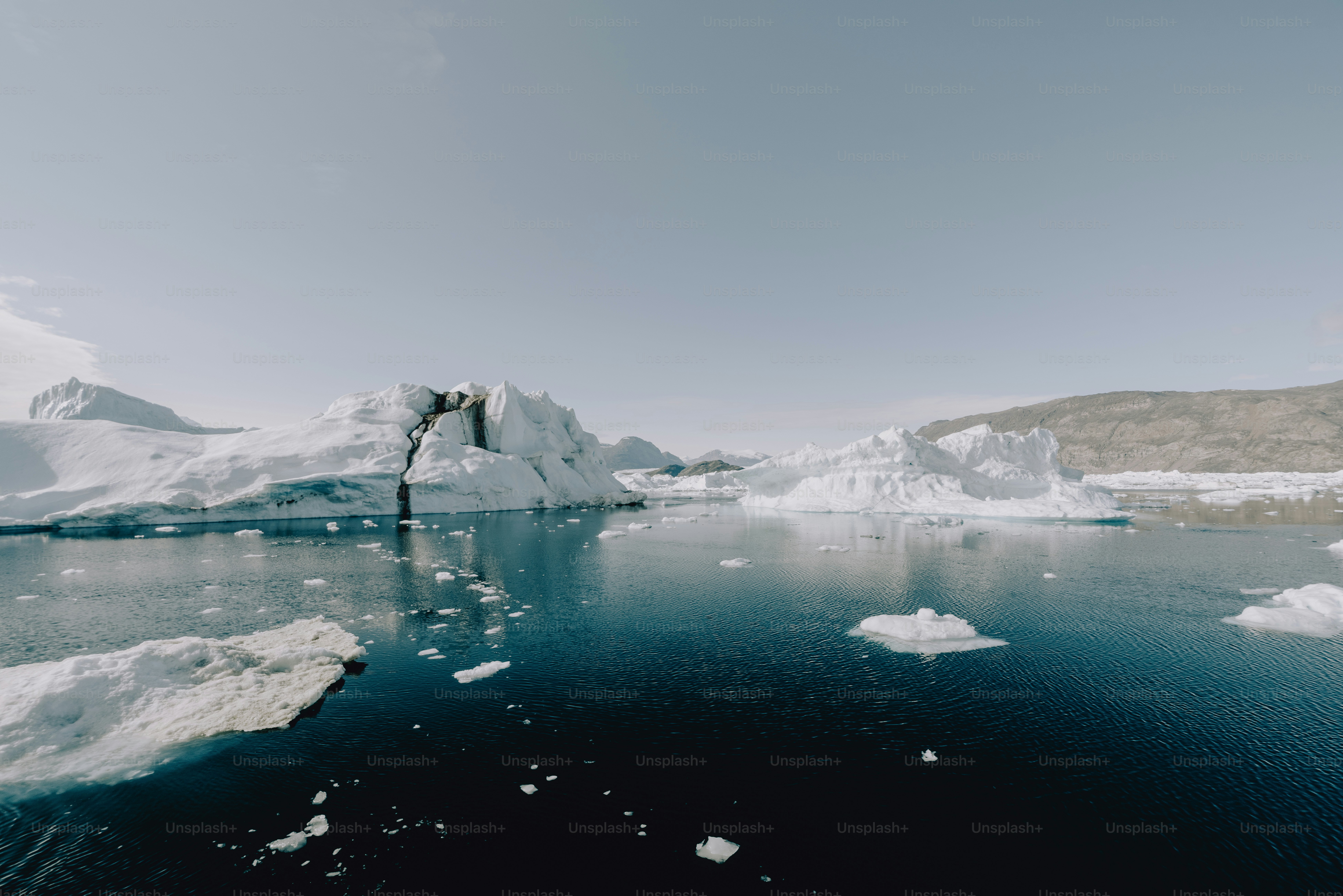 a body of water surrounded by icebergs and snow