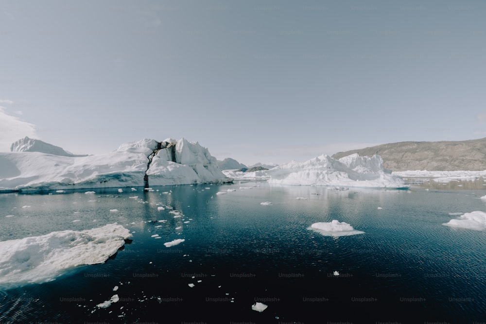 a body of water surrounded by icebergs and snow