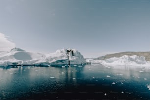 un grand iceberg flottant au milieu d’un plan d’eau