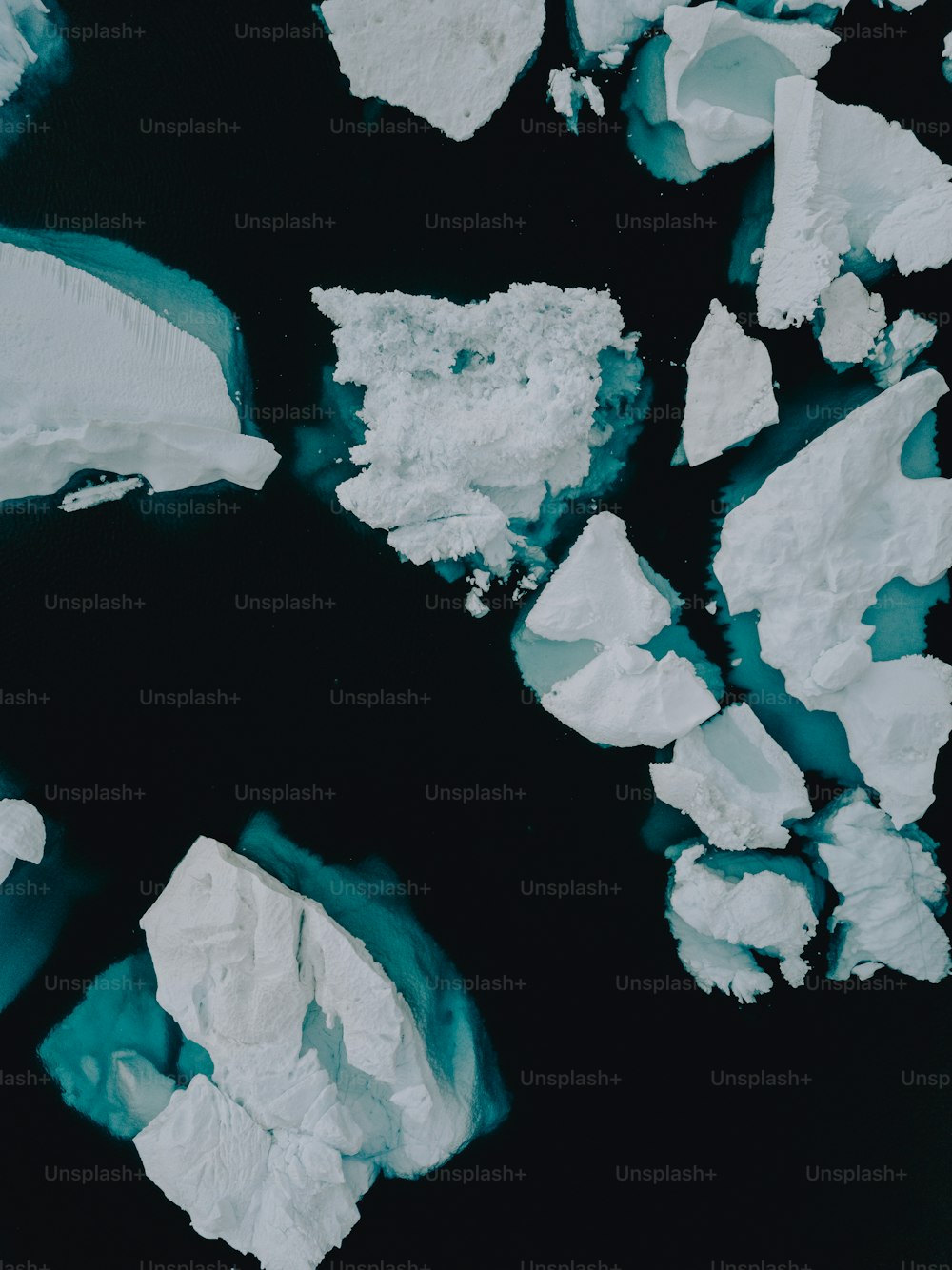 un groupe de morceaux de glace flottant au-dessus d’un plan d’eau