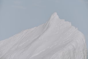 a person on a snowboard in front of a snow covered mountain
