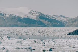 a large glacier with mountains in the background