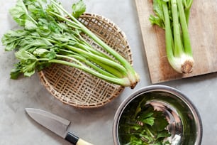 a bowl of celery next to a cutting board with a knife