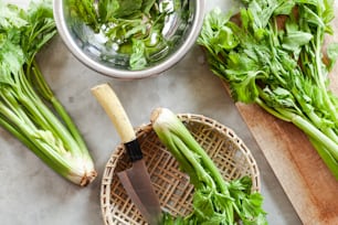 a cutting board topped with celery next to a knife