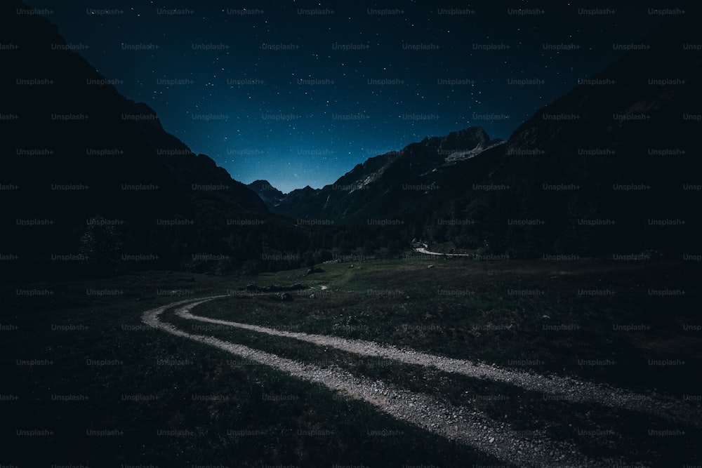 a dirt road in the middle of a mountain at night