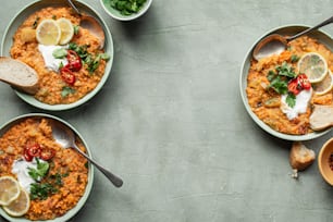 three bowls of food on a table with spoons