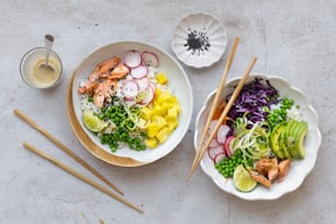 two bowls of food on a table with chopsticks