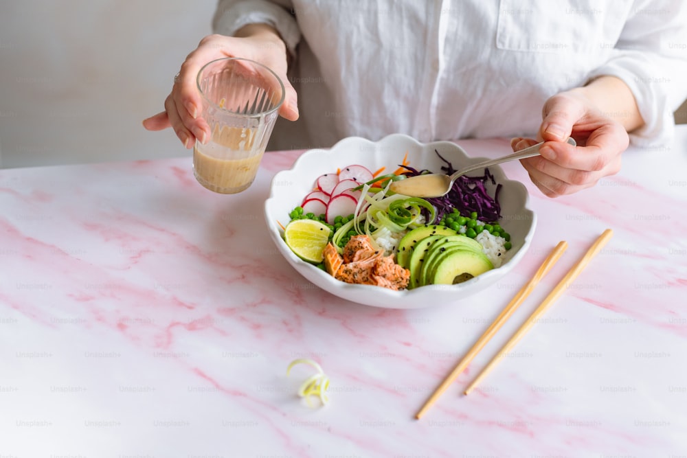 a person is holding a spoon over a bowl of food