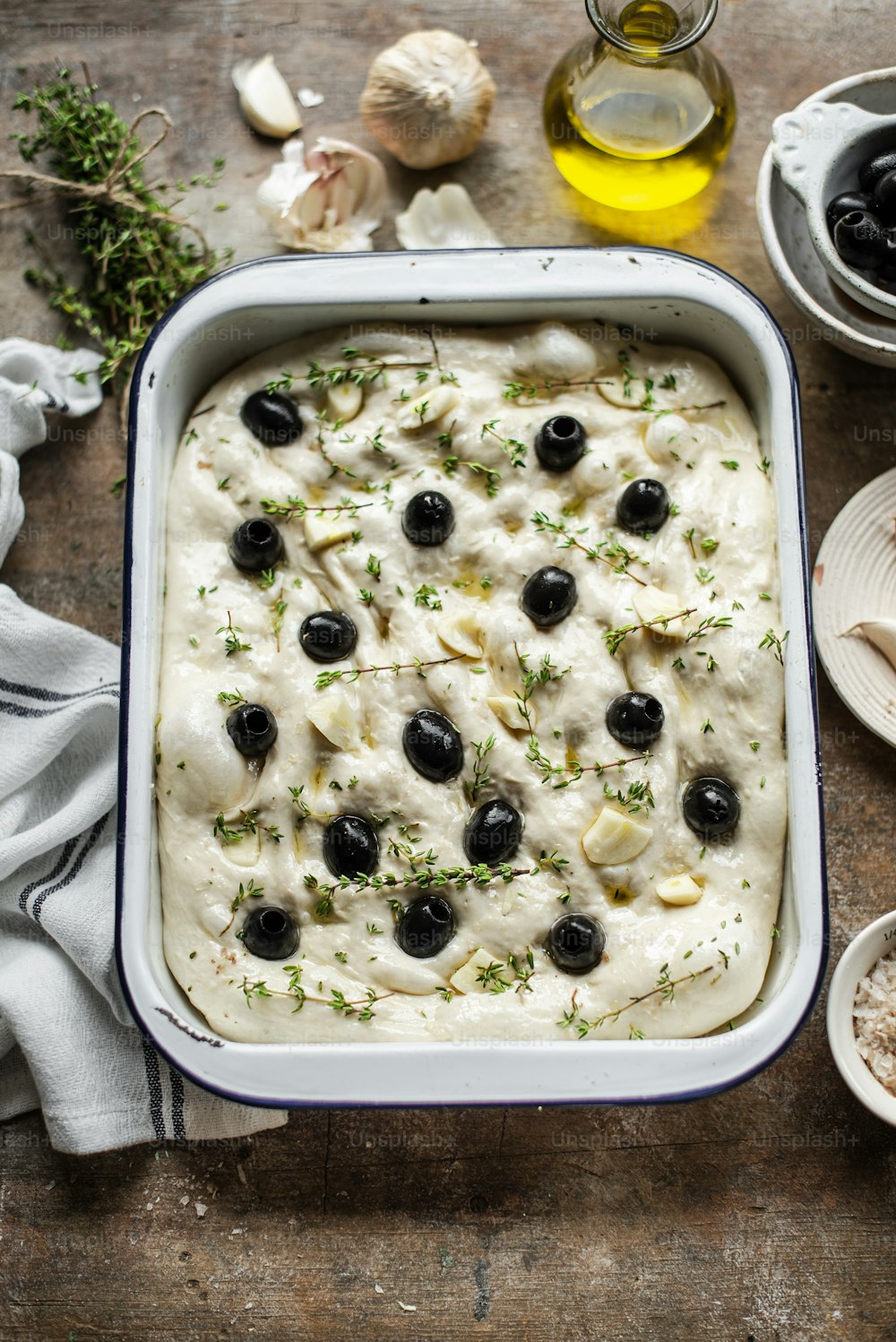 a casserole dish with olives and white sauce
