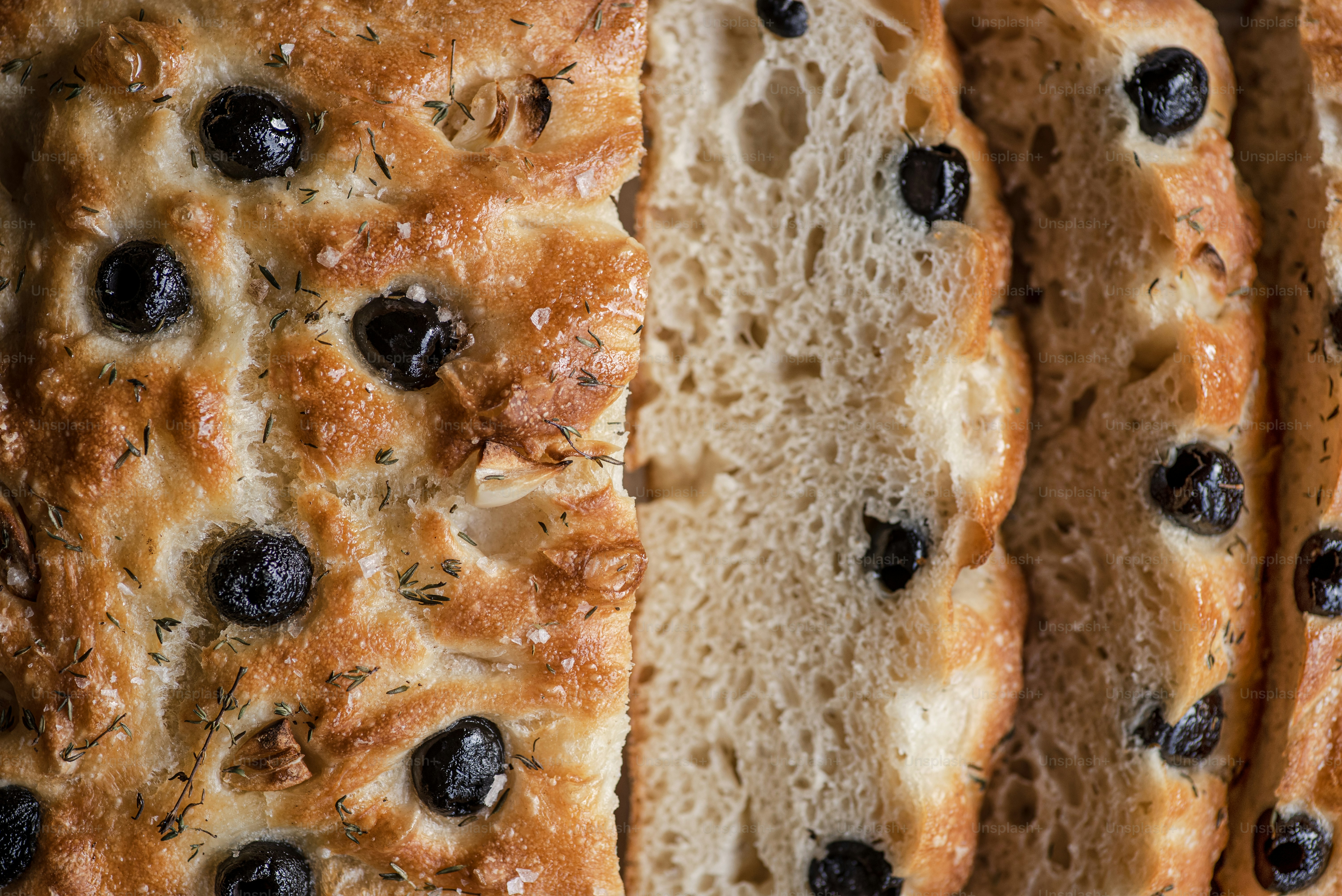 a close up of a loaf of bread with olives