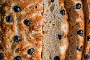 a close up of a loaf of bread with olives
